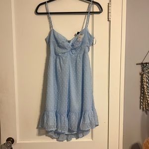 Polka dot textured babydoll dress. Tie back with bow and knot neckline